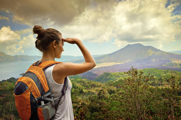 Naklejka premium Woman traveler looking at Batur volcano. Indonesia