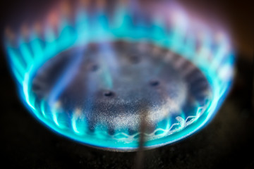 Blue flame gas stove in the dark. Selective focus.