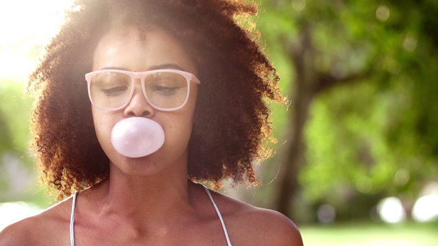 Happy Afro Girl blowing bubble gum in slow motion