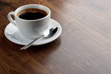 Coffee cup on a wooden table. Dark background.