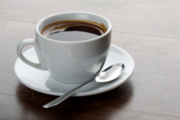 Coffee cup on a wooden table. Dark background.