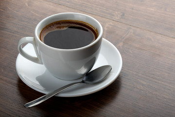 Coffee cup on a wooden table. Dark background.