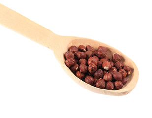 Wooden spoon with hazelnuts.