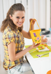 Fototapeta premium Happy young woman making easter basket