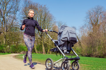 Young mother jogging with a baby buggy