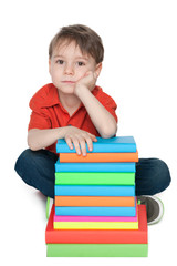 Thoughtful little boy with books