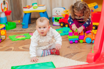 Fototapeta na wymiar Little girl playing with toys in the playroom