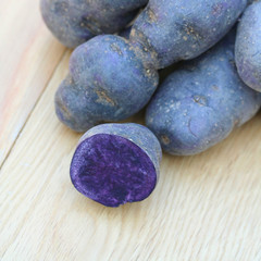 Fototapeta na wymiar patate viola su tavolo di legno