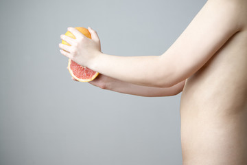 Female body with red grapefruit