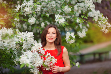 Fototapeta premium beautiful girl stands near a flowering tree