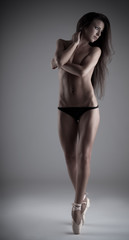 Young beautiful woman posing topless on tiptoe