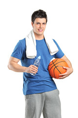 Male athlete holding bottle od water and a basketball