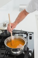 Close-up detail of a man preparing food in kitchen