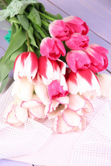 Beautiful tulips on color wooden background