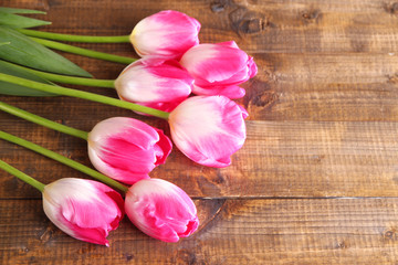 Beautiful tulips on color wooden background