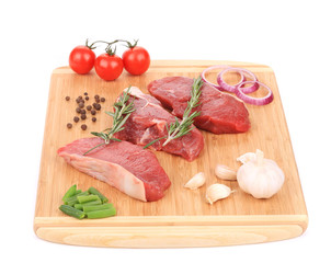 Raw beef steaks on a wooden cutting board.