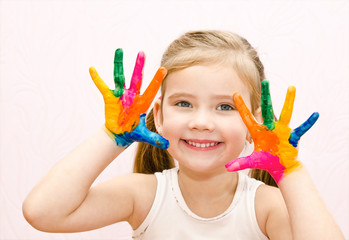 Cute smiling little girl with hands in paint
