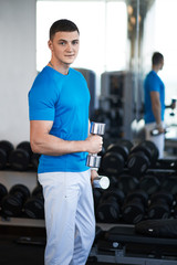 young guy is engaged with a dumbbell