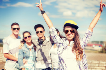 teenage girl with headphones and friends outside