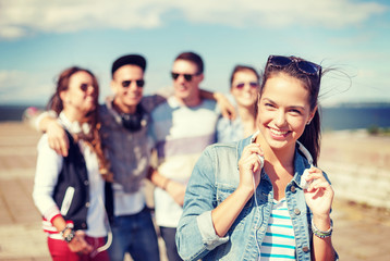 teenage girl with headphones and friends outside