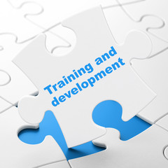 Education concept: Training and Development on puzzle background