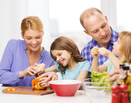 Happy Family With Two Kids Making Dinner At Home