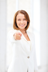 smiling businesswoman pointing finger at you