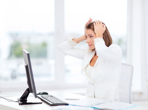 stressed businesswoman with computer at work