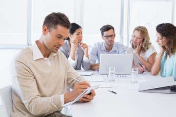 Obraz premium Casual businessman taking notes during meeting