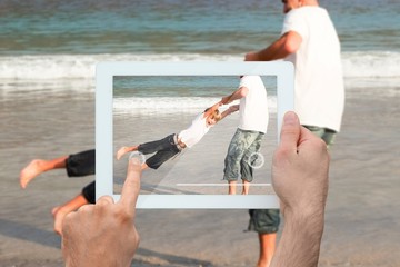 Composite image of hand holding tablet pc