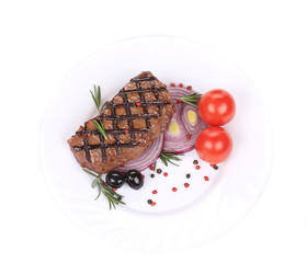Big juicy grilled steak with greens.