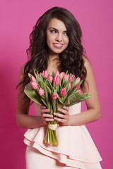 Smiling elegant woman with pink tulips