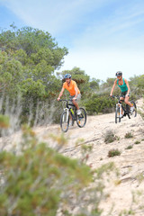 Fototapeta premium Couple riding bikes on island trail