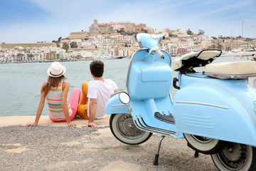 Tourists looking at the town of Ibiza, moto in foreground - obrazy, fototapety, plakaty