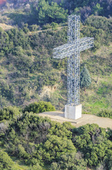cross against green forest, aerial shoot, vertical