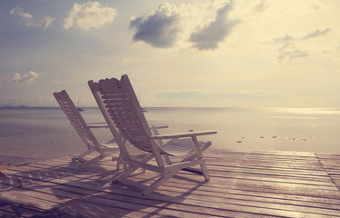 White wooden beach chair facing seascape,vintage filter effect