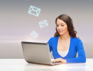 smiling woman in blue clothes with laptop computer