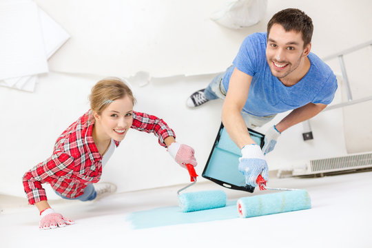 Smiling Couple Painting Wall At Home