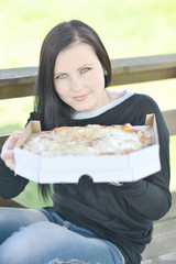 Young happy woman eating pizza in restaurant