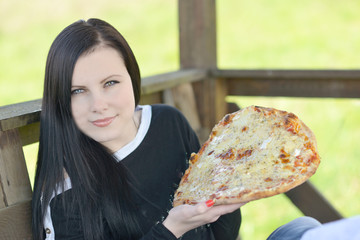 Young happy woman eating pizza