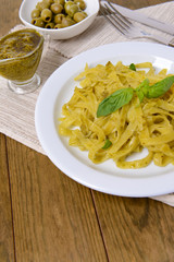 Delicious pasta with pesto on plate on table close-up