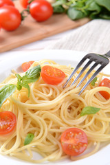 Delicious spaghetti with tomatoes on plate on table close-up