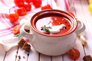 Tasty tomato soup and vegetables on wooden table
