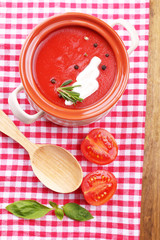 Tasty tomato soup on wooden table