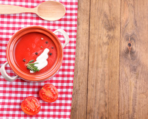 Tasty tomato soup on wooden table