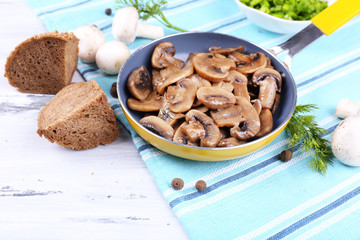 Delicious fried mushrooms in pan on table close-up