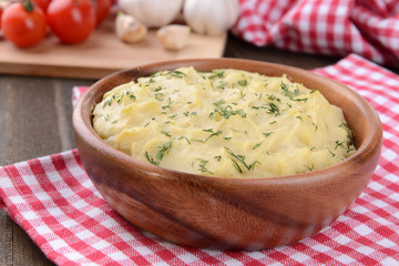 Delicious mashed potatoes with greens in bowl on table close-up