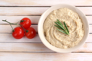 Bowl of tasty fresh hummus with tomatoes © Africa Studio