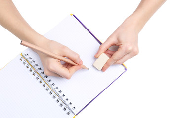 Human hands with pencil and erase rubber and notebook, isolated