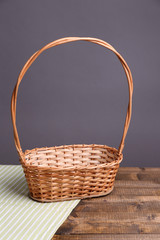 Fototapeta na wymiar Empty wicker basket on wooden table, on dark background